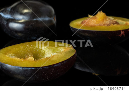 Fresh purple plum isolated on black glass 58403714