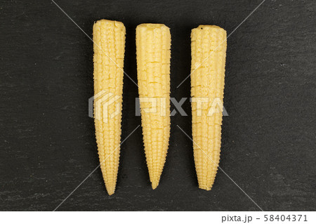 Pickled baby corn on grey stone 58404371