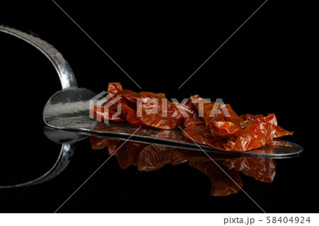 Dry red cherry tomato isolated on black glass Dry red cherry tomato isolated on black glass 58404924