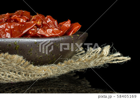 Dry red cherry tomato isolated on black glass Dry red cherry tomato isolated on black glass 58405169
