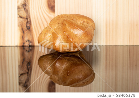 Golden baked profiterole on glass with wood Golden baked profiterole on glass with wood 58405379