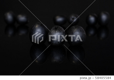 Pickled black olive isolated on black glass Pickled black olive isolated on black glass 58405584