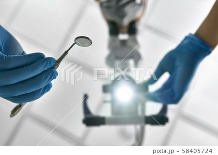 Doctor is using dental microscope during his work Doctor is using dental microscope during his work 58405724