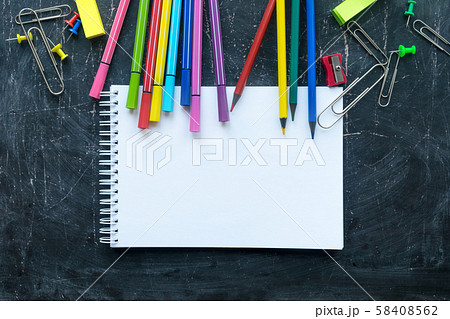 School supplies and notebook on a chalkboard 58408562
