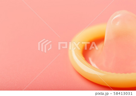 Opened condom on a pink background, close-up, top 58413031