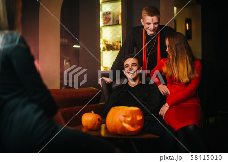 Group of four friends celebrating Halloween in a cafe 58415010