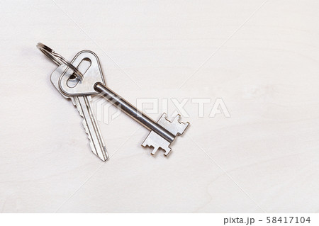 door keys on keyring on pale brown table 58417104