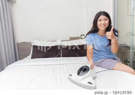Girl maid cleaning bedroom and using bed vacuum to clean dust mite Girl maid cleaning bedroom and using bed vacuum to clean dust mite 58419590