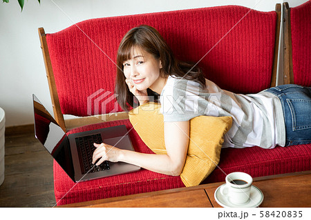 寝転がってパソコンをする女性 58420835