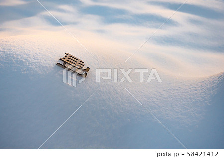 Toy on white snow. Sleigh on snowy hills and valleys. Toy of wooden sleigh on snow background 58421412