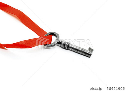 Vintage silver key with red ribbon on white 58421906
