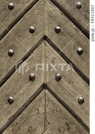Fragment of old wooden doors with metal rivets 58421907