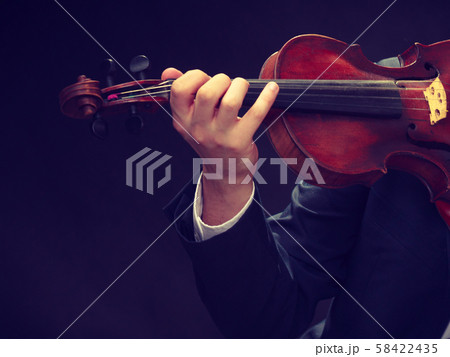 Man man dressed elegantly playing violin 58422435