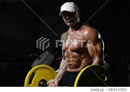 Brutal strong athletic men pumping up muscles 58423302