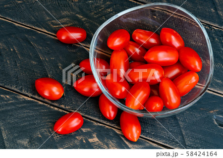 Close up fresh cherry tomato in glass cup on wood 58424164