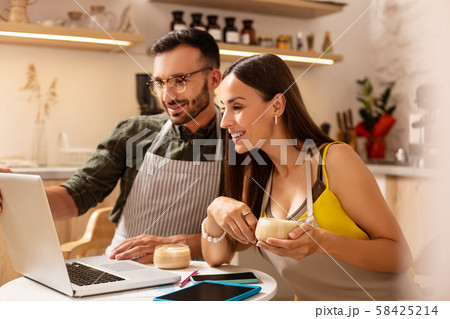 Wife drinking coffee with husband and planning menu Wife drinking coffee with husband and planning menu 58425214