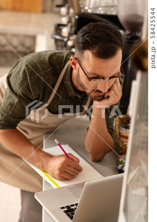 Owner of coffee shop writing points for future development Owner of coffee shop writing points for future development 58425544