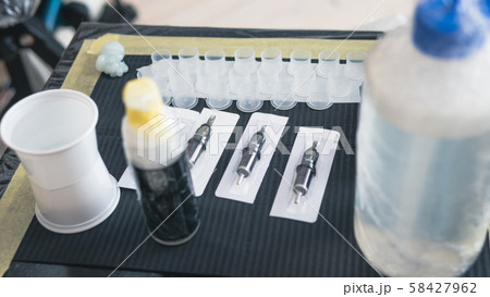 Close-up of tattoo artist work place parts and paint, machines and other equipment. Close-up of tattoo artist work place parts and paint, machines and other equipment. 58427962