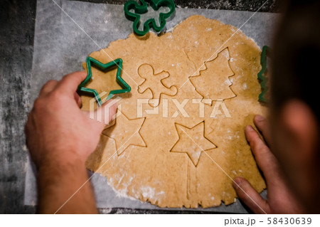 male hands cut out gingerbread cookie in the form 58430639