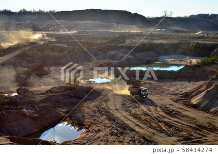 Dump truck transports sand and other minerals in the mining quarry. 58434274