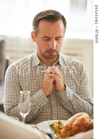 Man praying at the table 58434540