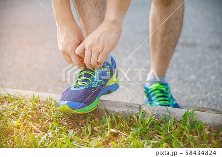 Man runner tying running shoes before run for 58434824