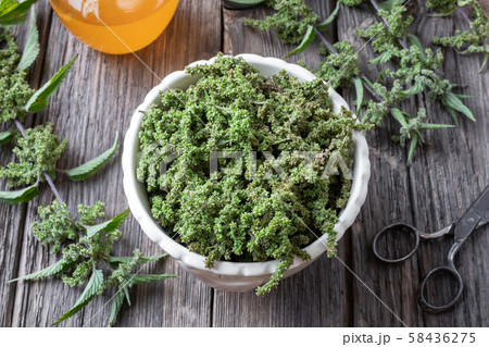 Nettle seeds in a bowl with a jar of honey 58436275
