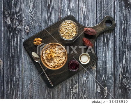 Oatmeal porridge with dates in a cardboard cup.  58438910