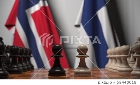 Flags of Norway and Finland behind pawns on the chessboard. Chess game or political rivalry related 58440019