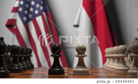 Flags of USA and Singapore behind pawns on the chessboard. Chess game or political rivalry related 58440401