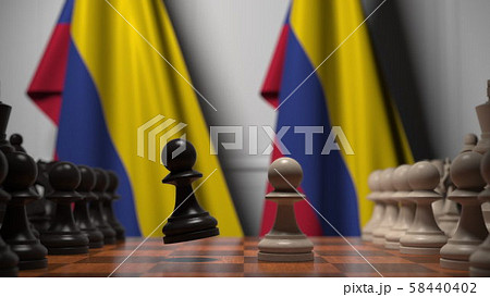 Flags of Colombia behind pawns on the chessboard. Chess game or political rivalry related 3D 58440402