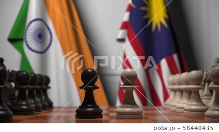 Flags of India and Malaysia behind pawns on the chessboard. Chess game or political rivalry related 58440435