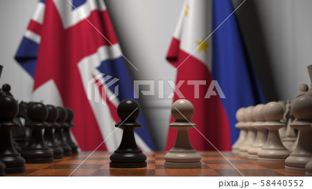Flags of Great Britain and Philippines behind pawns on the chessboard. Chess game or political 58440552
