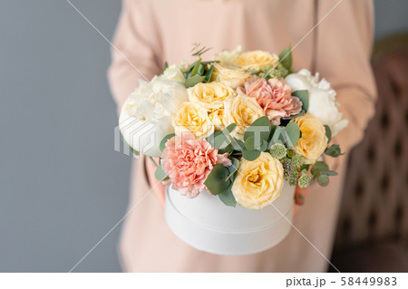 Small Beautiful bouquet in a round box. Bunch of mixed flowers in woman hand. Floral shop concept 58449983