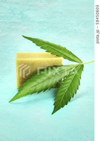 Homemade hemp soap bar with a cannabis leaf on a blue backgrround with copyspace Homemade hemp soap bar with a cannabis leaf on a blue backgrround with copyspace 58450603