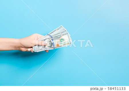 Image of female hand holding a bundle of dollars 58451133