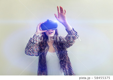 Smile young woman wearing using virtual reality VR glasses helmet headset on white background 58455375