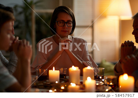 Family praying before dinner at home Family praying before dinner at home 58457917