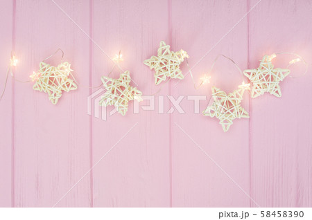 Christmas lights garland with stars border over pink background. Flat lay, copy space Christmas lights garland with stars border over pink background. Flat lay, copy space 58458390