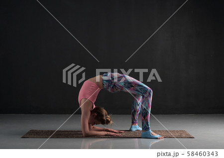 woman doing asana chakrasana or urdva dhanurasana or wheel pose. Hard variation. woman doing asana chakrasana or urdva dhanurasana or wheel pose. Hard variation. 58460343