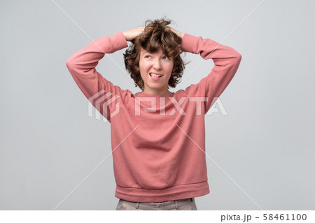 Smiling curly thinking woman looking up dreaming or planning 58461100