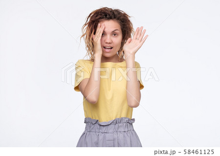 Cute shy asian girl peeping at you through hands 58461125