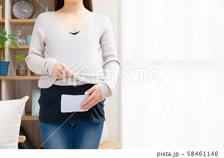 使い捨てカイロをお腹につける妊婦 使い捨てカイロをお腹につける妊婦 58461146