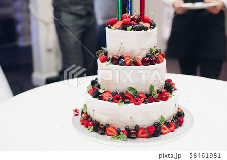 Three-layered wedding cake with fresh berries Three-layered wedding cake with fresh berries 58461981