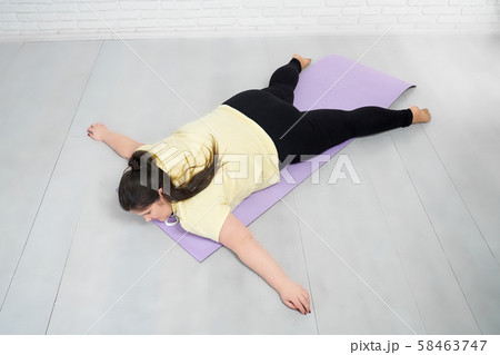Fat girl lying on violet mat in star pose after training 58463747