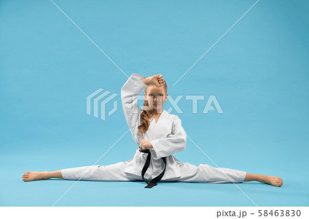 Girl in white kimono with black belt making cross twine. Girl in white kimono with black belt making cross twine. 58463830