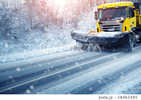 Truck cleaning on winter road covered with snow 58465495