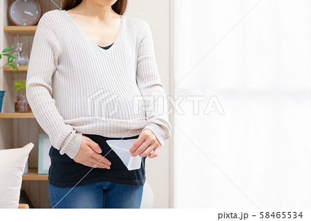 お腹のカイロを剥がす妊婦 お腹のカイロを剥がす妊婦 58465534