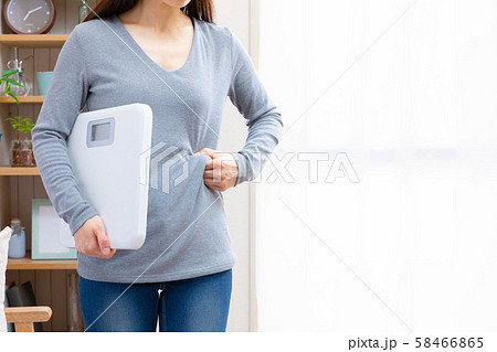 お腹周りを気にする女性 58466865