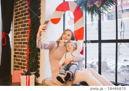 christmas, technology and family concept, happy mother and little son taking selfie smartphone at christmas, technology and family concept, happy mother and little son taking selfie smartphone at 58466870